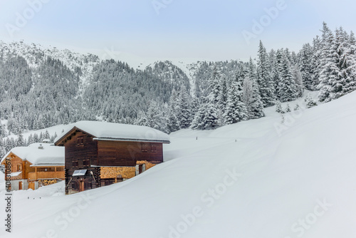 Isolated summer chalet and villages high up on the Swiss Alps covered in fresh powder snow near Davos © gdefilip