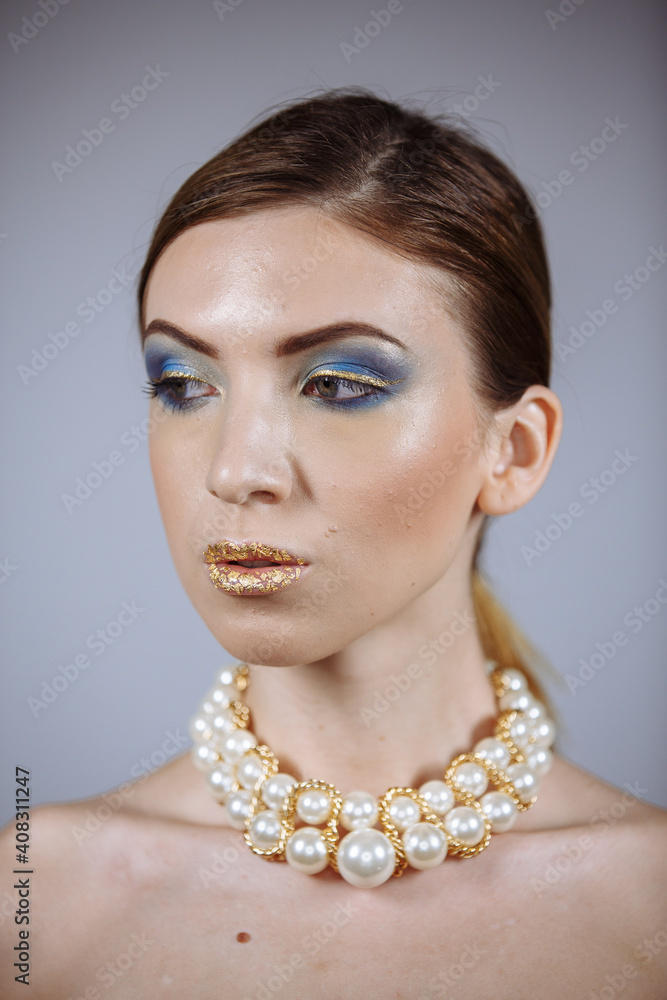 portrait of a girl with a large necklace and gold lips