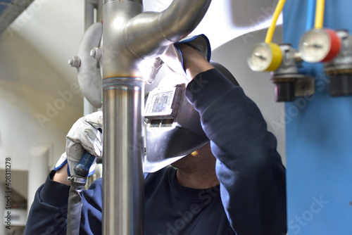 Fotografie welder works in steel construction and repairs an industrial plant
