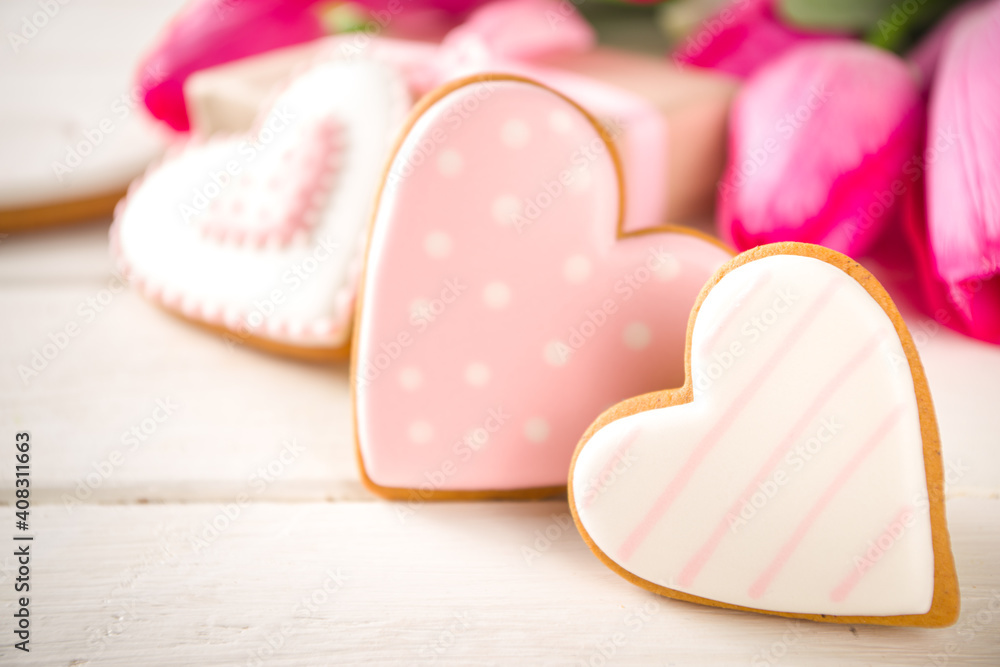 Valentine Day concept, Spring Woman Day Holiday, Mothers Day background, Red tulip flowers bouquet, craft paper gift box, heart shaped traditional sugar cookies, White wooden background copy space Valentine Day concept, Spring Woman Day Holiday, Mothers Day background, Red tulip flowers bouquet, craft paper gift box, heart shaped traditional sugar cookies, White wooden background copy space