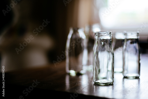 selective focus of empty glass bottle on wooden table