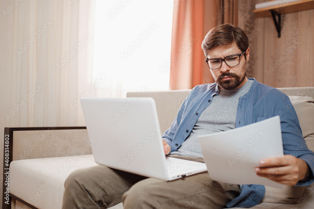 Entrepreneur works with a laptop and keeps a document in a home office Entrepreneur works with a laptop and keeps a document in a home office