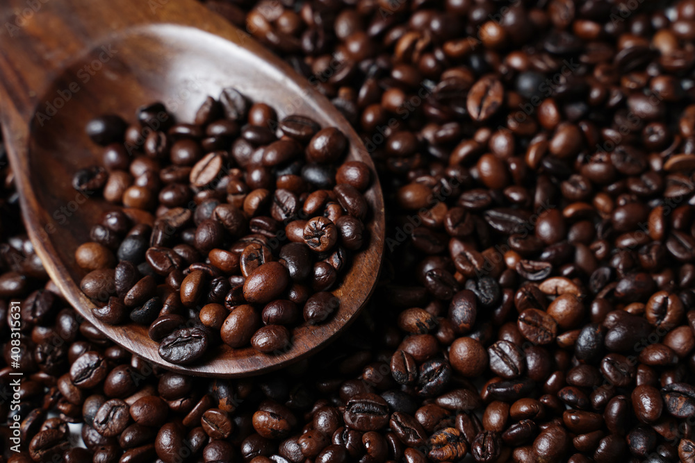 Scoop out ripe coffee beans using a large spoon made of wood and iron. Coffee beans scattered on the floor. Details texture of dark brown coffee beans. Graphic resourches for design template. Scoop out ripe coffee beans using a large spoon made of wood and iron. Coffee beans scattered on the floor. Details texture of dark brown coffee beans. Graphic resourches for design template.