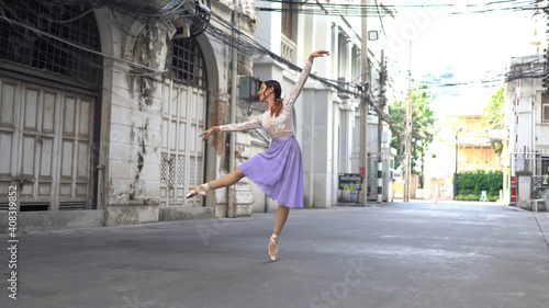 Young beautiful ballerina dancing along the street