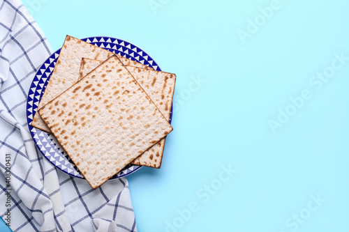 Plate with Jewish flatbread matza for Passover on color background photo