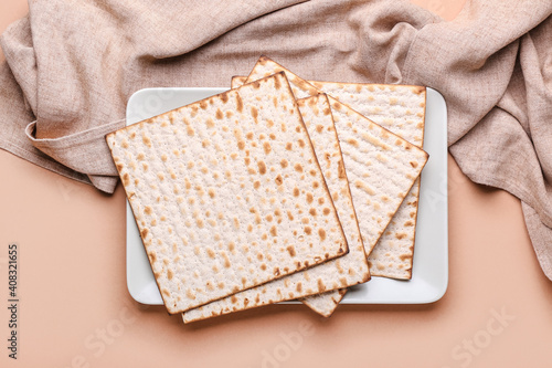 Plate with Jewish flatbread matza for Passover on color background photo