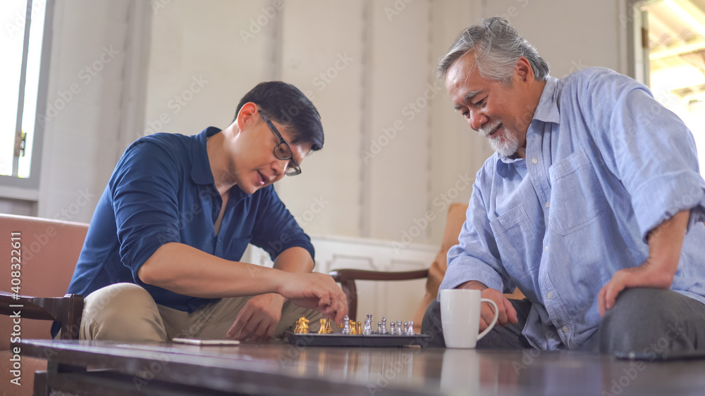 Asian Senior man playing chess with son Asian Senior man playing chess with son