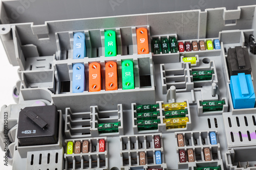 Automotive fuses on a white panel with holders and multi-colored markings - a protective device that opens the electrical circuit when the rated current in the circuit is exceeded. Electrical Repair. photo