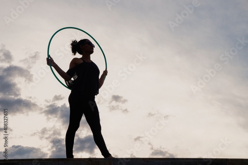 Woman playing with dance hoop in the afternoon