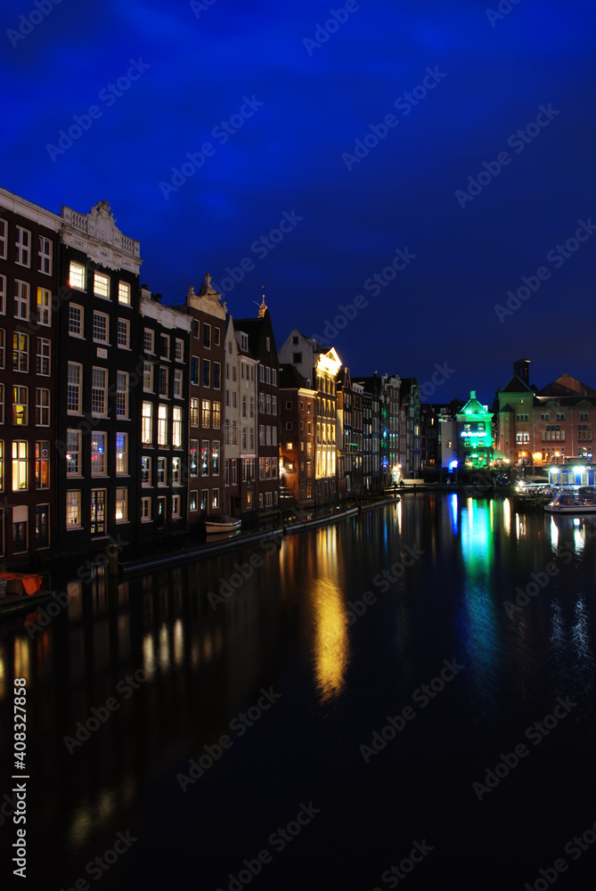 Evening view of the former river mouth of Amstel and picturesque  architecture of Amsterdam from Damrak street. 