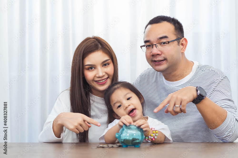 family savings, budget planning, children's pocket money.Asian family mother farther and daughter show piggy bank moneybox family savings, budget planning, children's pocket money.Asian family mother farther and daughter show piggy bank moneybox