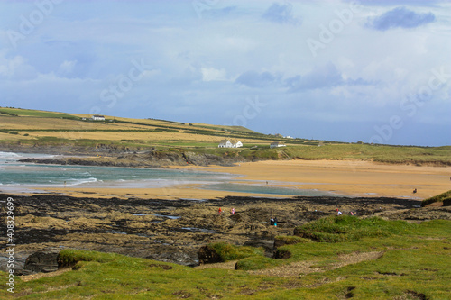coastal seascape with green headland ,rocky outcrops , golden empty beaches with waves and surf sea.