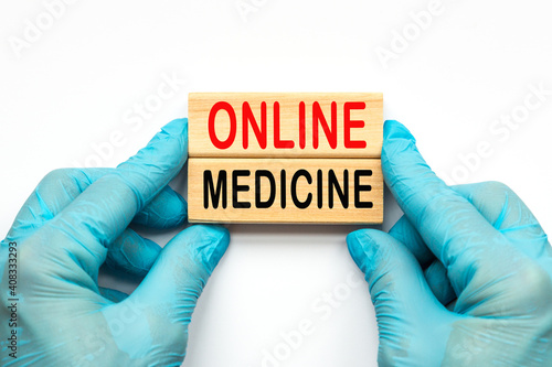 The doctor's hands show the word ONLINE MEDICINE . a gloved hand on a white background. Medical concept. the medicine