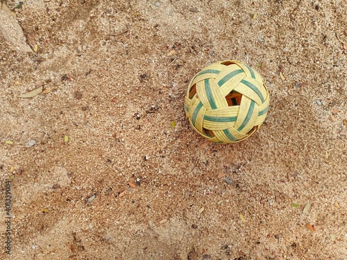 yellow-green rattan ball on the sand with free copy space.