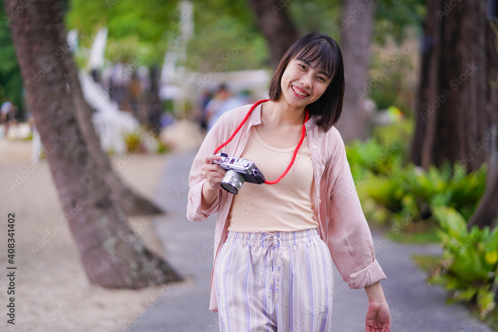 Asian travelling woman be smile with classic 35mm rangefinder film camera, woman relaxing in holiday summer Asian travelling woman be smile with classic 35mm rangefinder film camera, woman relaxing in holiday summer