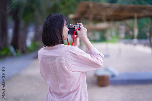 Asian travelling woman be smile with classic 35mm rangefinder film camera, woman relaxing in holiday summer © pangoasis