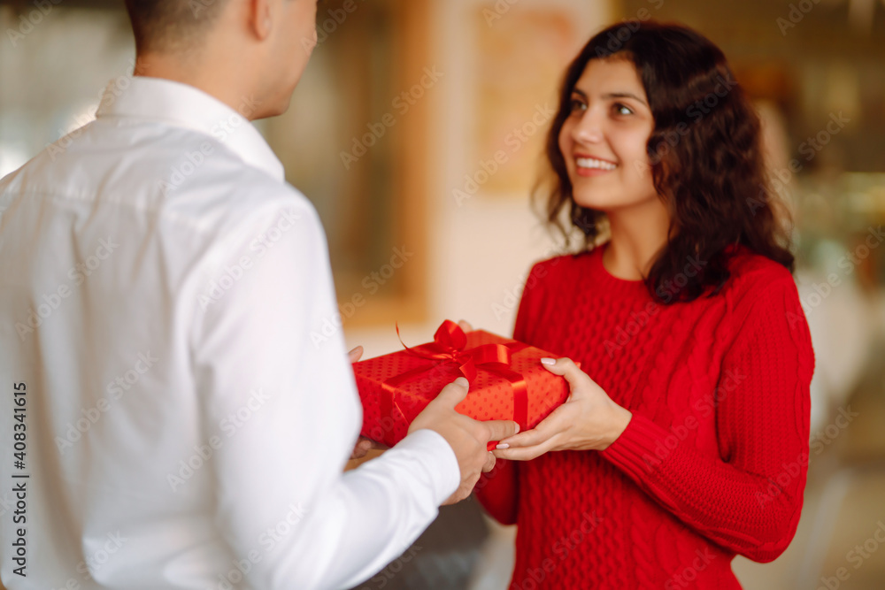 Exchange of gifts. Young couple in love offering gift to each other for valentine day or birthday. Romantic day. Winter holidays. Exchange of gifts. Young couple in love offering gift to each other for valentine day or birthday. Romantic day. Winter holidays.