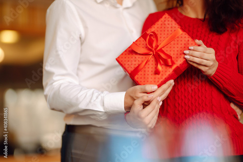 Exchange of gifts.  Young couple in love offering gift to each other for valentine day or birthday. Romantic day. Winter holidays. © maxbelchenko