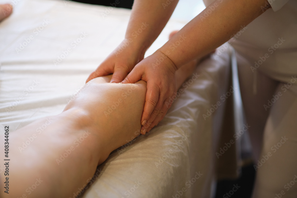 Detail of hands massaging human calf muscle.Therapist applying pressure on female leg. Hands of massage therapist massaging legs of young woman in spa salon. Body care in spa salon for young woman. Detail of hands massaging human calf muscle.Therapist applying pressure on female leg. Hands of massage therapist massaging legs of young woman in spa salon. Body care in spa salon for young woman.