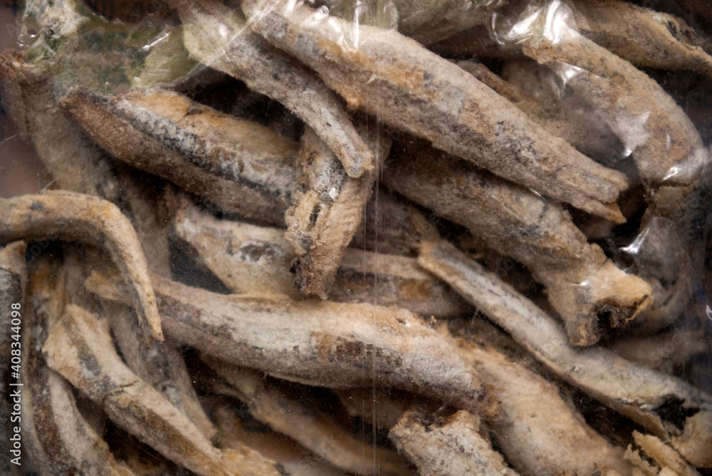 Dried salted anchovies in a transparent package . Snack Fish to beer.  Full frame.