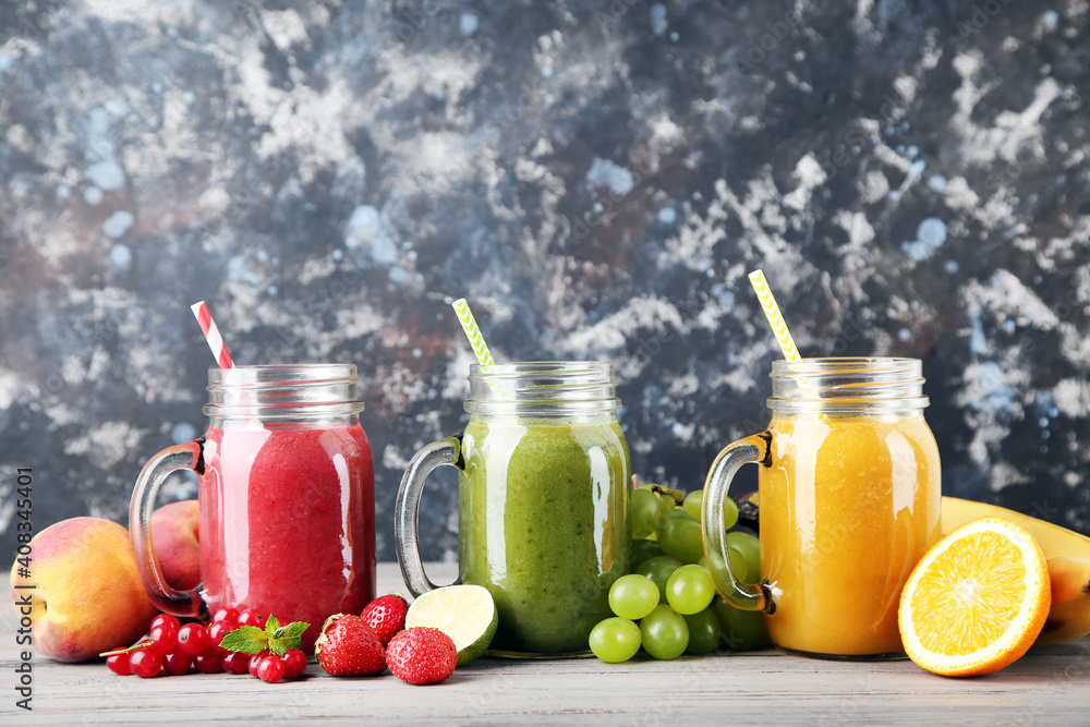 Fresh smoothies in glass jars with fruits and vegetables on wooden background Fresh smoothies in glass jars with fruits and vegetables on wooden background