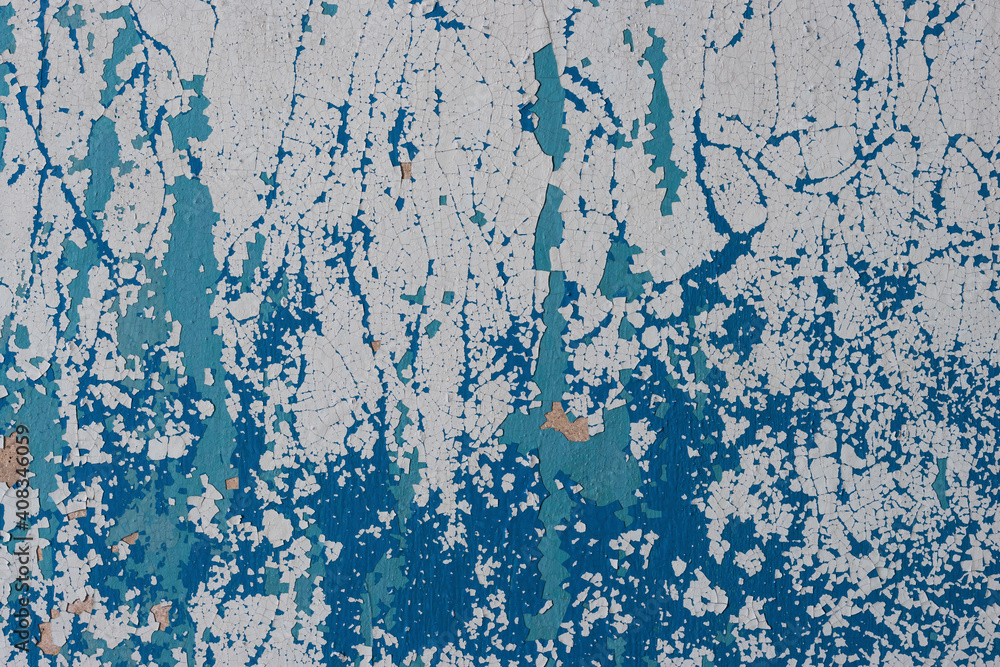 Fototapeta premium Peeling paint on the wall. Old concrete wall with cracked flaking paint. Weathered rough painted surface with patterns of cracks and peeling. High resolution texture for background and design. Closeup