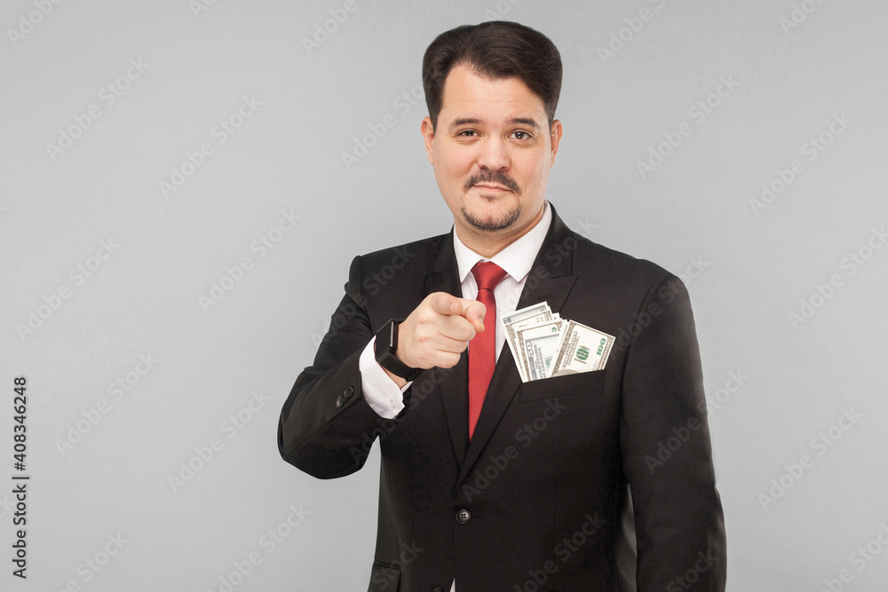 Handsome businessman pointing finger at camera with little smile Handsome businessman pointing finger at camera with little smile