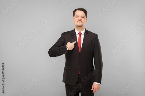 Man in classic wear pointing himself at camera