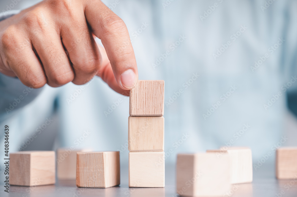 Businessman wearing a blue shirt, arranging the empty wooden blocks with his hands. Which is placed on a white wooden table. Business strategy and action plan. Copy space. Businessman wearing a blue shirt, arranging the empty wooden blocks with his hands. Which is placed on a white wooden table. Business strategy and action plan. Copy space.