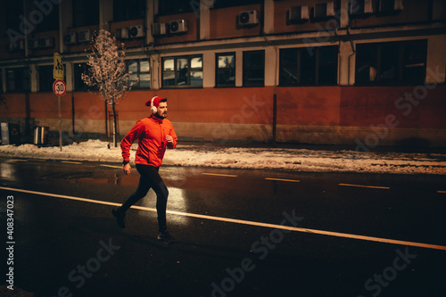 Man running on empty city street on winter night