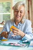 Senior Woman Doing Craft Scrapbooking Or Making Greetings Card  At Home