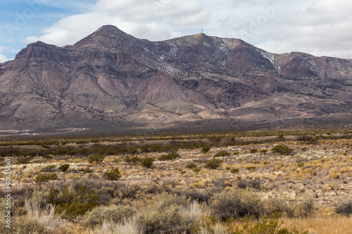 Light brushes of snow on mountain scape behind vast desert vista landscape in rural New Mexico