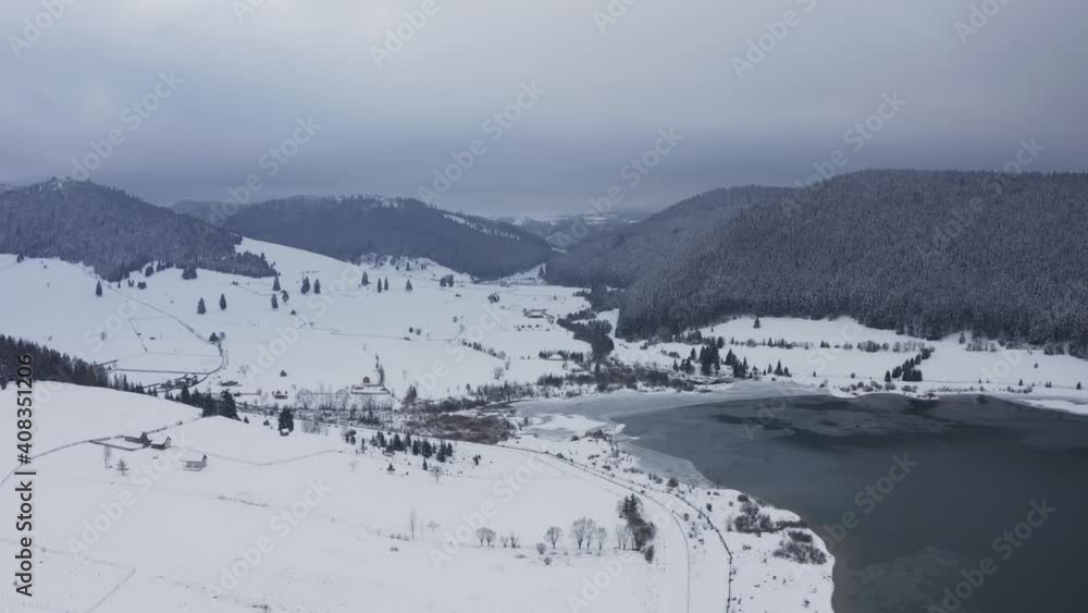 Snowy mountainous landscape and frozen lake. Aerial pedestal down Snowy mountainous landscape and frozen lake. Aerial pedestal down