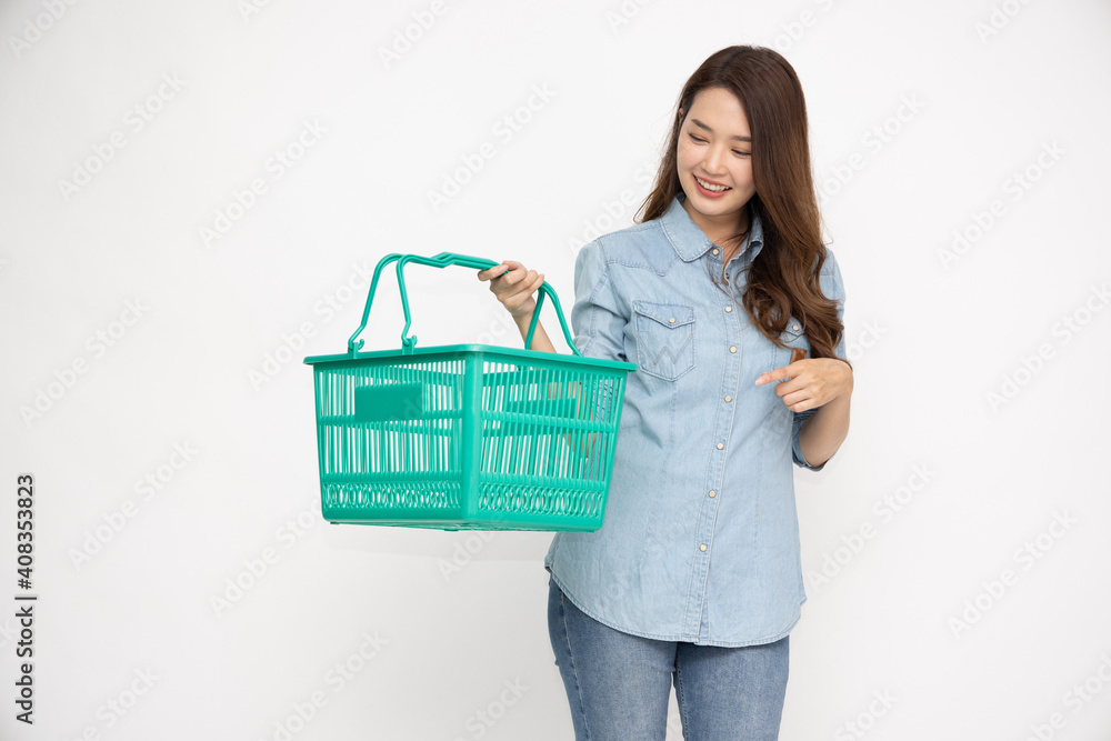 Beautiful Asian woman wearing jean shirt smiling and holding shopping basket isolated on white background Beautiful Asian woman wearing jean shirt smiling and holding shopping basket isolated on white background