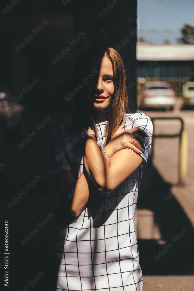 Young woman crossed arms in dark shadow oudoor