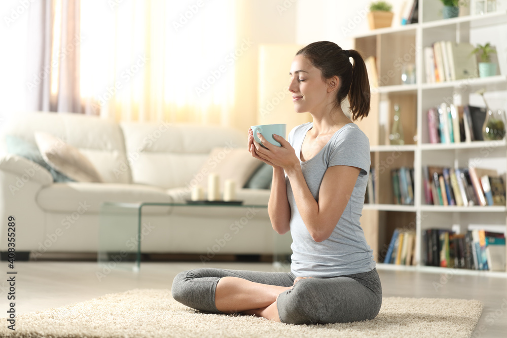 Yogi drinking tea after yoga exercises at home