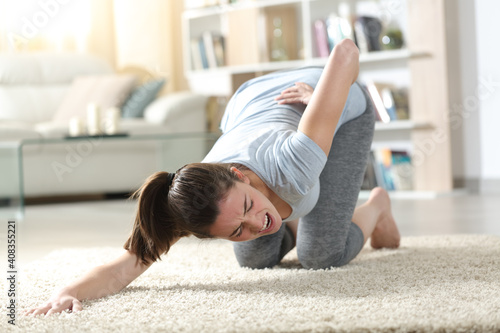 Obraz na plátne Woman suffering back ache exercising yoga at home
