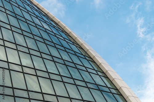 Fragment of a glass office building against a blue sky