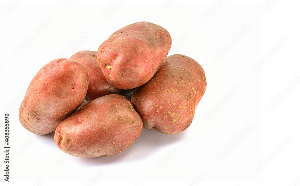 Raw pink potato tubers on a white isolated background.Potatoes in the skin. Raw pink potato tubers on a white isolated background.Potatoes in the skin.