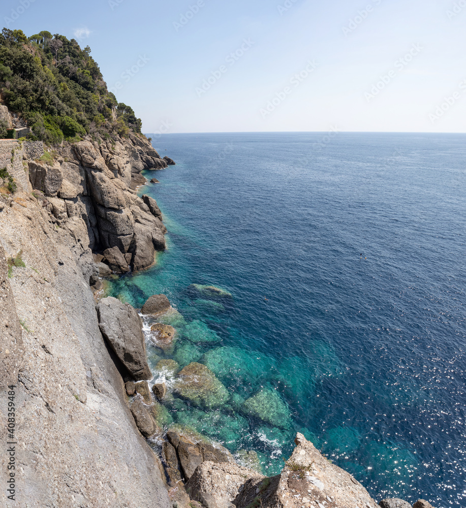 Cliff plunging into blue ocean in portofino italy. Spring and Summer holiday vacation concept.