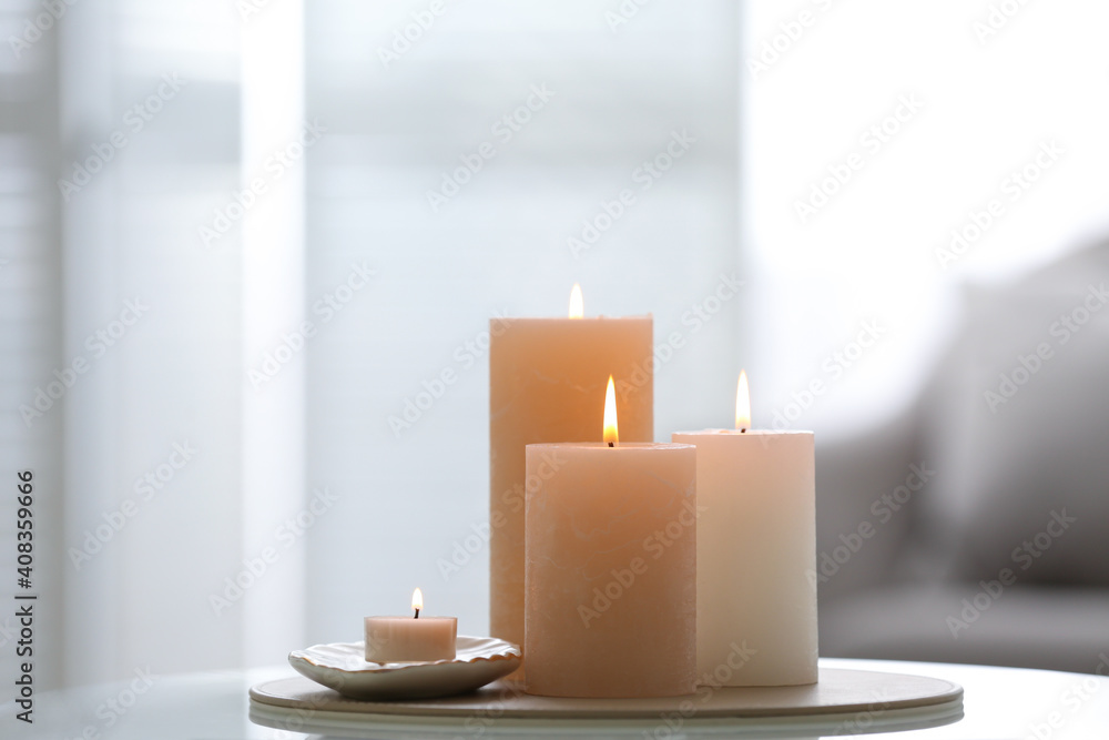 Burning candles on table indoors, space for text. Interior elements Burning candles on table indoors, space for text. Interior elements