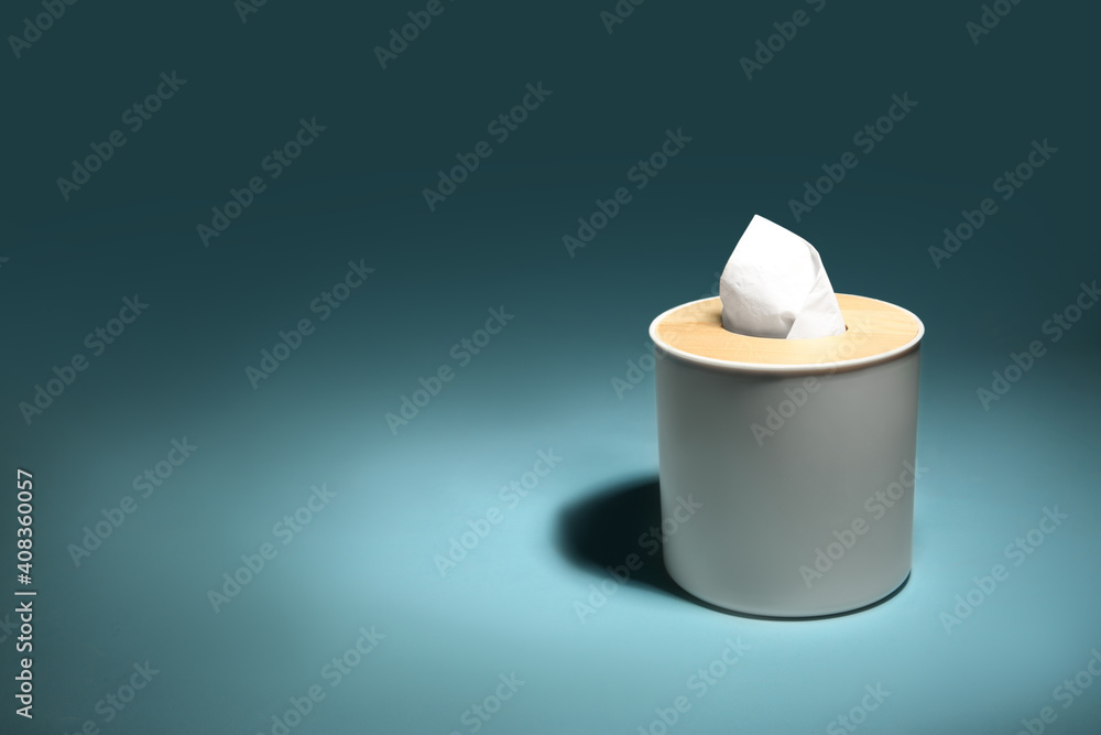 Holder with paper tissues on blue background. Space for text Holder with paper tissues on blue background. Space for text