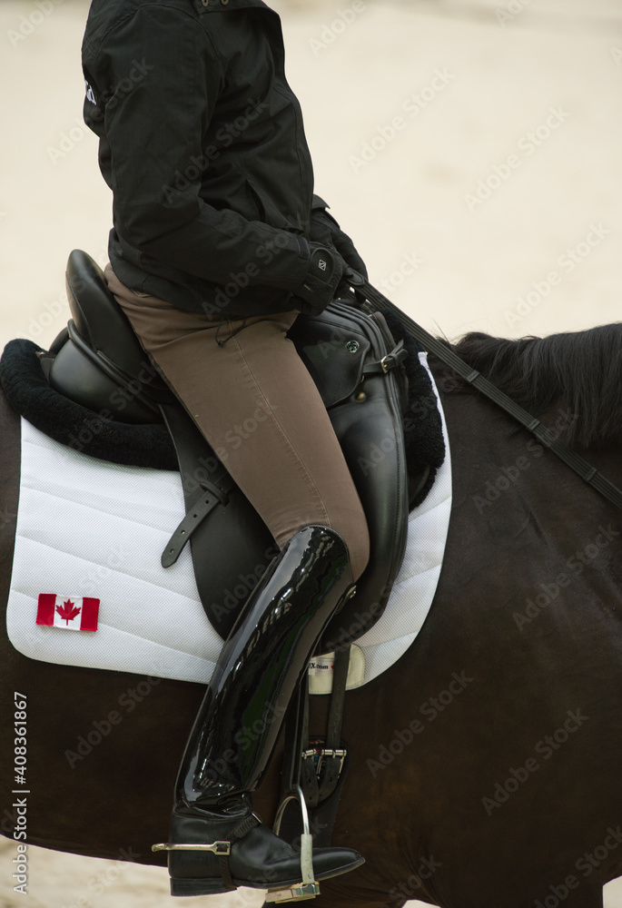 female equestrian rider competing for Canada at dressage horse show with proper attire tall