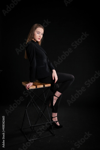 image of a model girl in a black suit on a black background