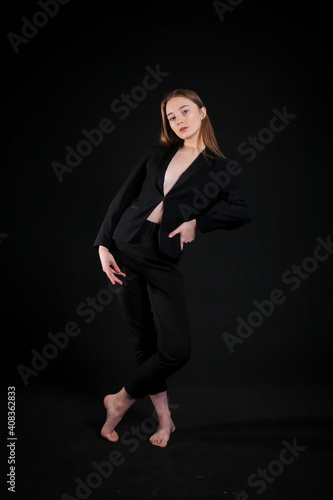 image of a model girl in a black suit on a black background © Владимир Андреев