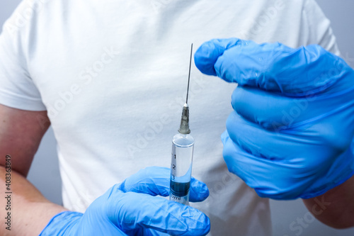 male doctor hands in blue medical gloves holding a syringe. Vaccination. Medical concept vaccination
