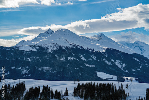 beautiful view of the snow capped hohe tauern in austria on a sunny winter day with foehn storm on the mountains