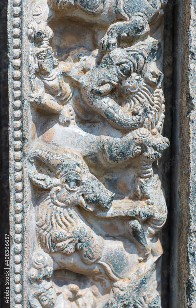 Lakkundi, Karnataka, India - November 6, 2013: Kasivisvesvara Temple, Defaced humans and damaged elephants gray stone sculpture on outside wall.