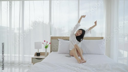 beautiful Asian woman stretch oneself on her bed in the morning.
 photo