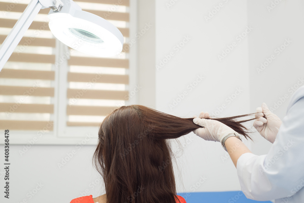 Doctor dermatologist doing hair loss test on female patient with long dark hair. Diagnostics of the hair and scalp diseases Stock Photo | Adobe Stock Doctor dermatologist doing hair loss test on female patient with long dark hair. Diagnostics of the hair and scalp diseases Stock Photo | Adobe Stock